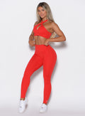 front profile picture of a model in our Smooth Leggings and the matching bra in Cherry Bomb color
