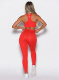 back profile of a model wearing the Smooth Leggings and the matching bra in Cherry Bomb color