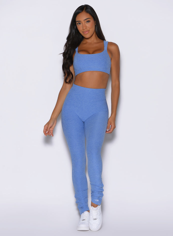 front profile view of a model wearing the Snape Flare Leggings in boss blue color paired with the matching bra 