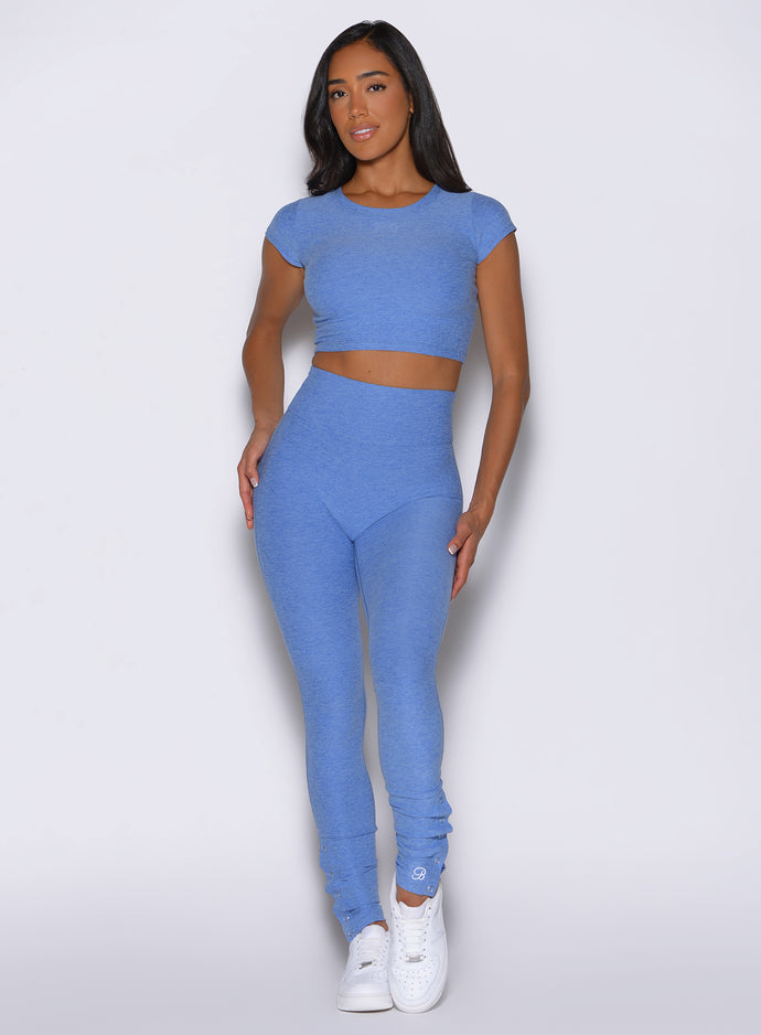 front profile view of a model wearing the Snape Flare Leggings in boss blue color paired with the matching tee