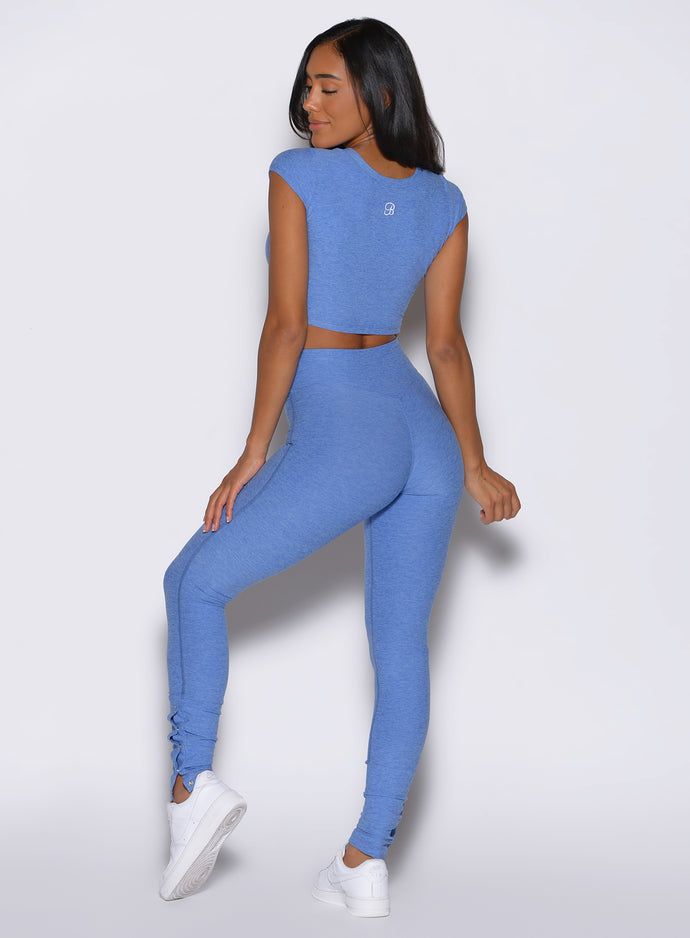 back profile view of a model facing to the left side wearing the Snape Flare Leggings in boss blue color