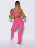 back profile view of a model wearing the Snape Flare Leggings in pink glo color