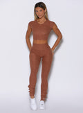 front profile view of a model wearing the Snape Flare Leggings in spiced chai color paired with the matching tee