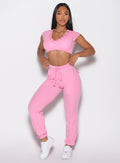 front profile view of a model wearing the Snap Rib Joggers in Pink Cupcake color paired with the matching top