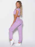 left side profile view of a model looking over her shoulder wearing the Snap Rib Joggers in Spring Fairy color