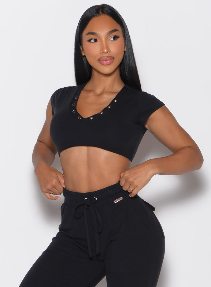 front profile view of a model looking to the left side wearing the Snap Top in black color