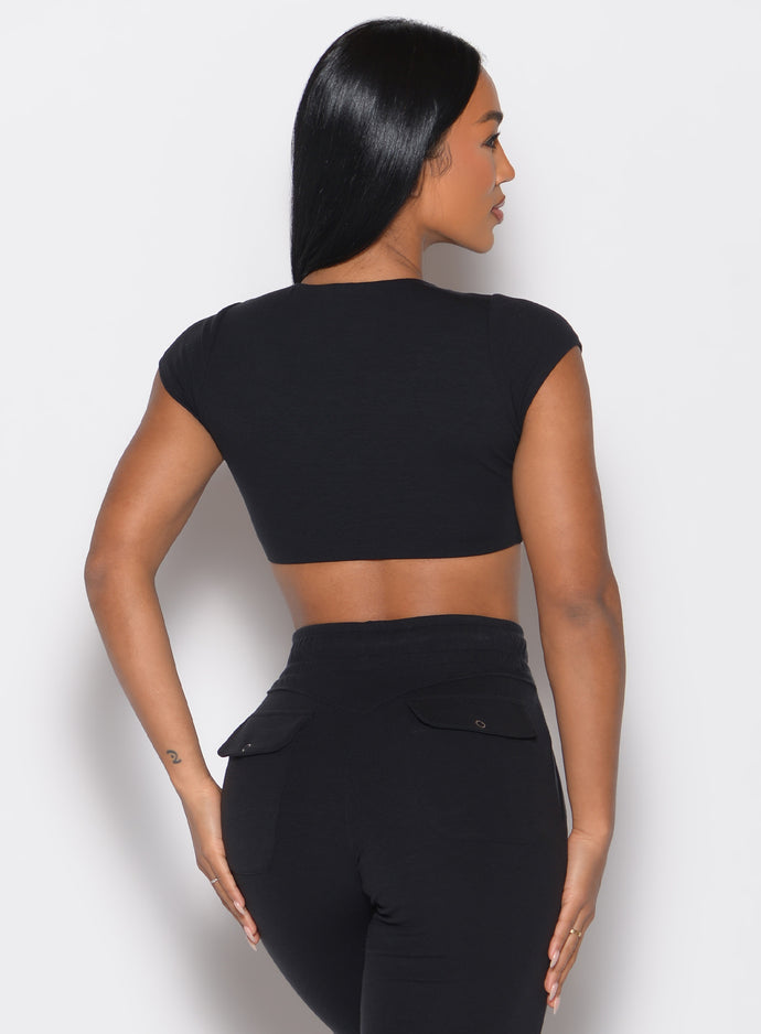 back profile view of a model facing to the right side wearing the Snap Top in black color