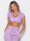 front profile view of a model with both hands inside the pockets wearing the Snap Top in Spring Fairy color