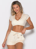 front profile view of a model wearing the Snap Top in Vanilla Cream color paired with the matching shorts 