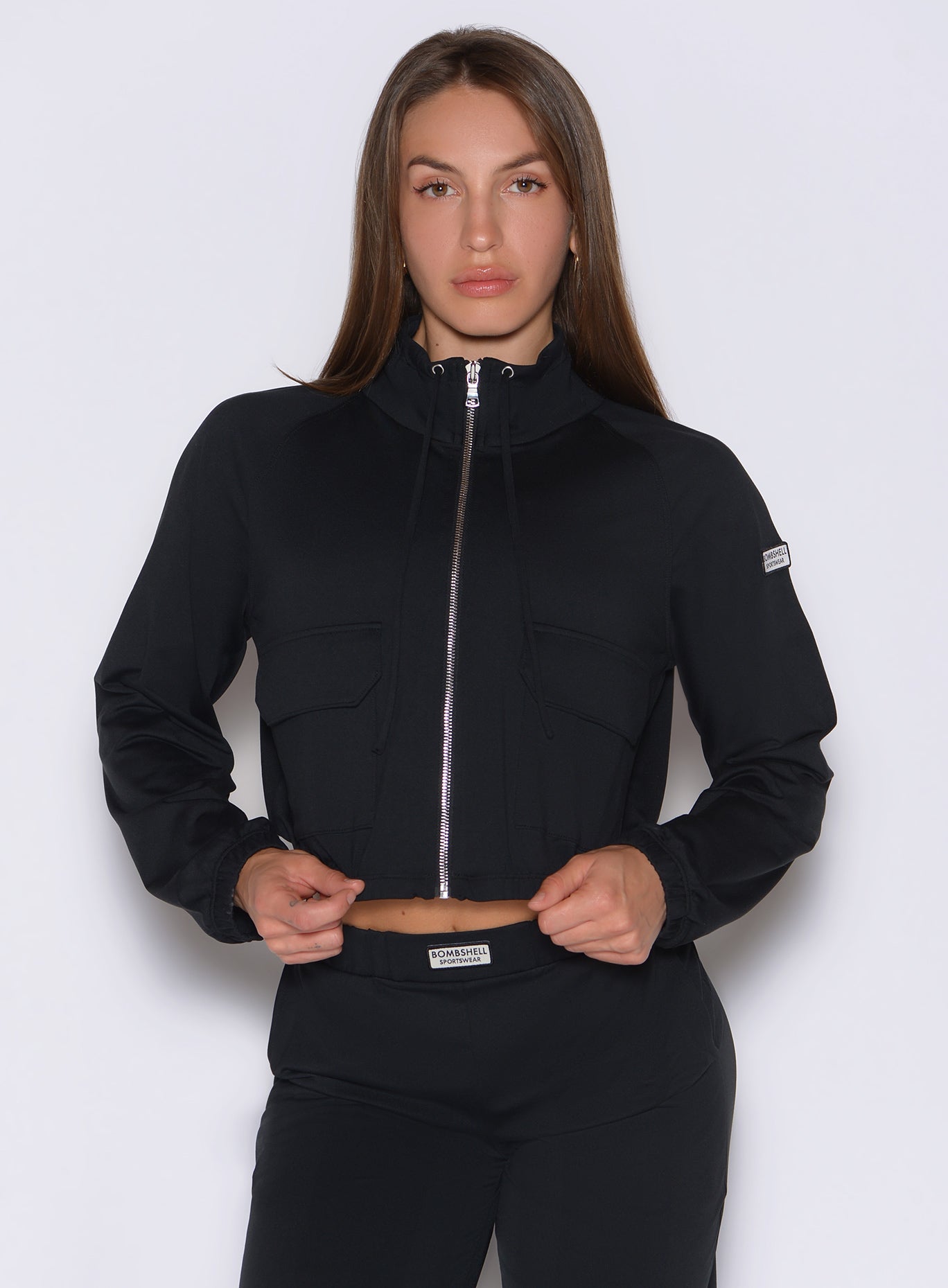 front view of a model wearing the Society Bomber Jacket in black color paired with the matching joggers