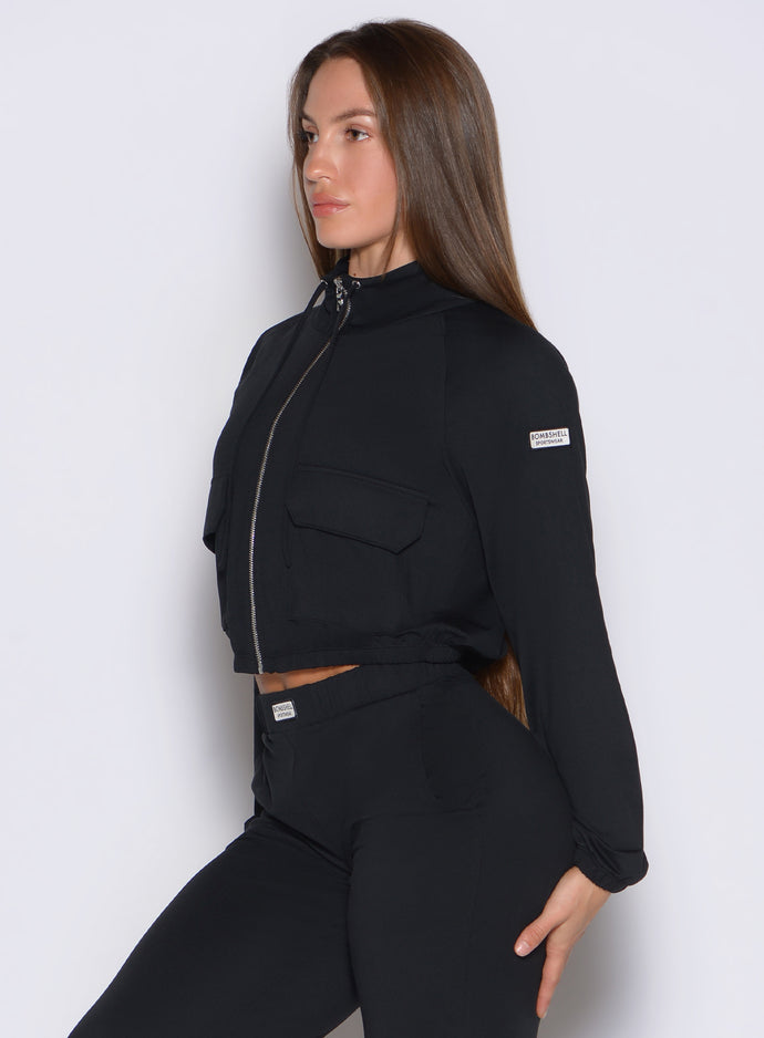 left side profile view of a model wearing the Society Bomber Jacket in black color