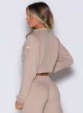 back left side view of a model wearing the Society Bomber Jacket in camel color
