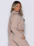 right side profile view of a model looking over her shoulder wearing the Society Bomber Jacket in camel color