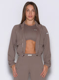 frontal view of a model wearing the Society Bomber Jacket in espresso color paired with the matching tank