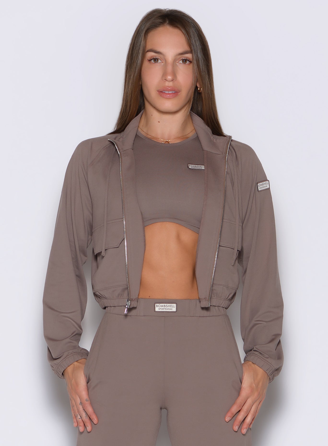frontal view of a model wearing the Society Bomber Jacket in espresso color paired with the matching tank