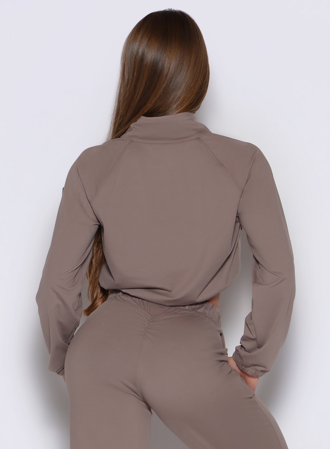 back side view of a model wearing the Society Bomber Jacket in espresso color