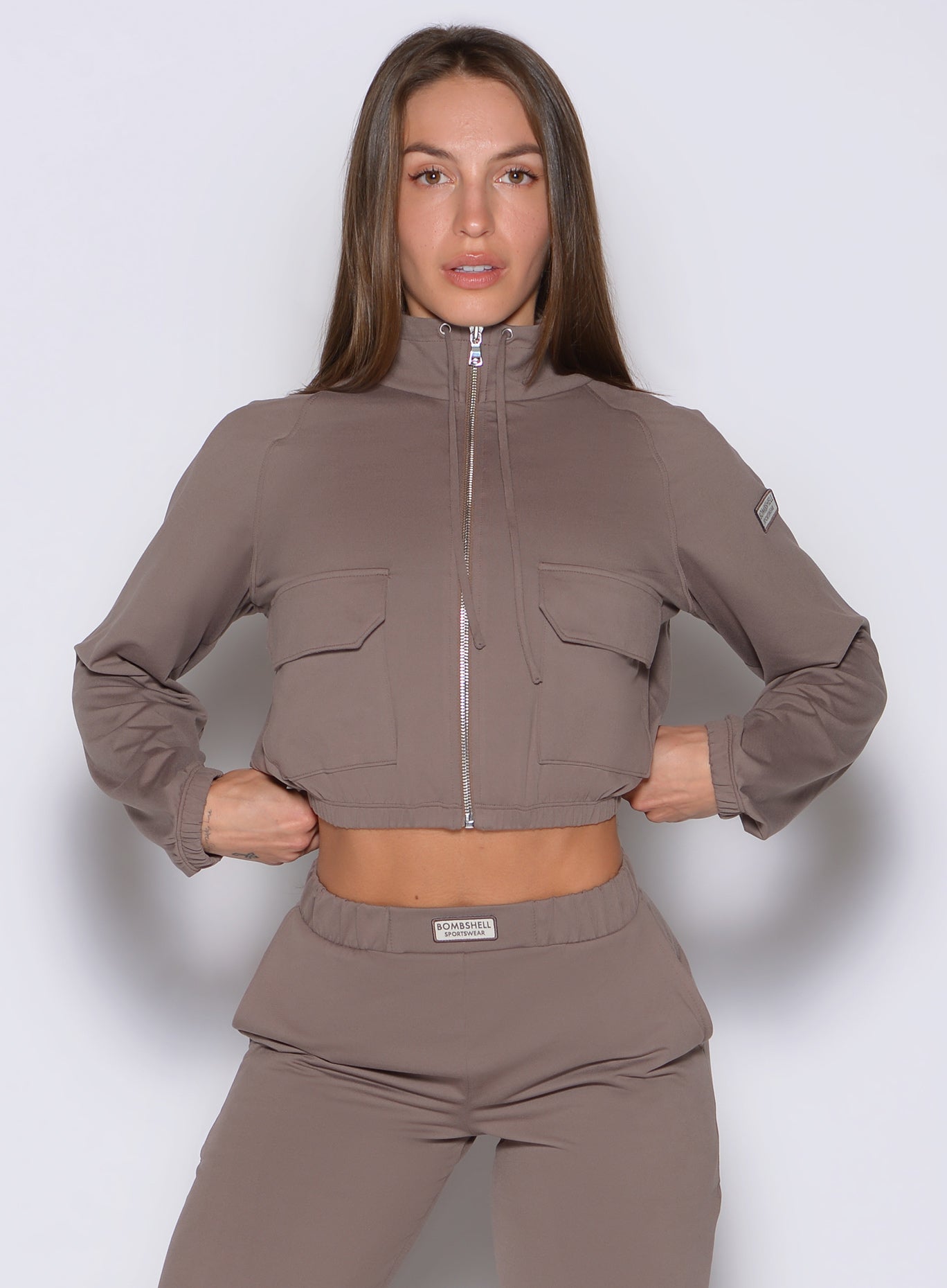 front view of a model wearing the Society Bomber Jacket in espresso color paired with the matching joggers
