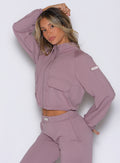 front left side profile view of a model wearing the Society Bomber Jacket in light mauve color paired with the matching joggers 