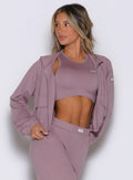 front profile view of a model wearing the Society Bomber Jacket in light mauve color paired with the matching tank