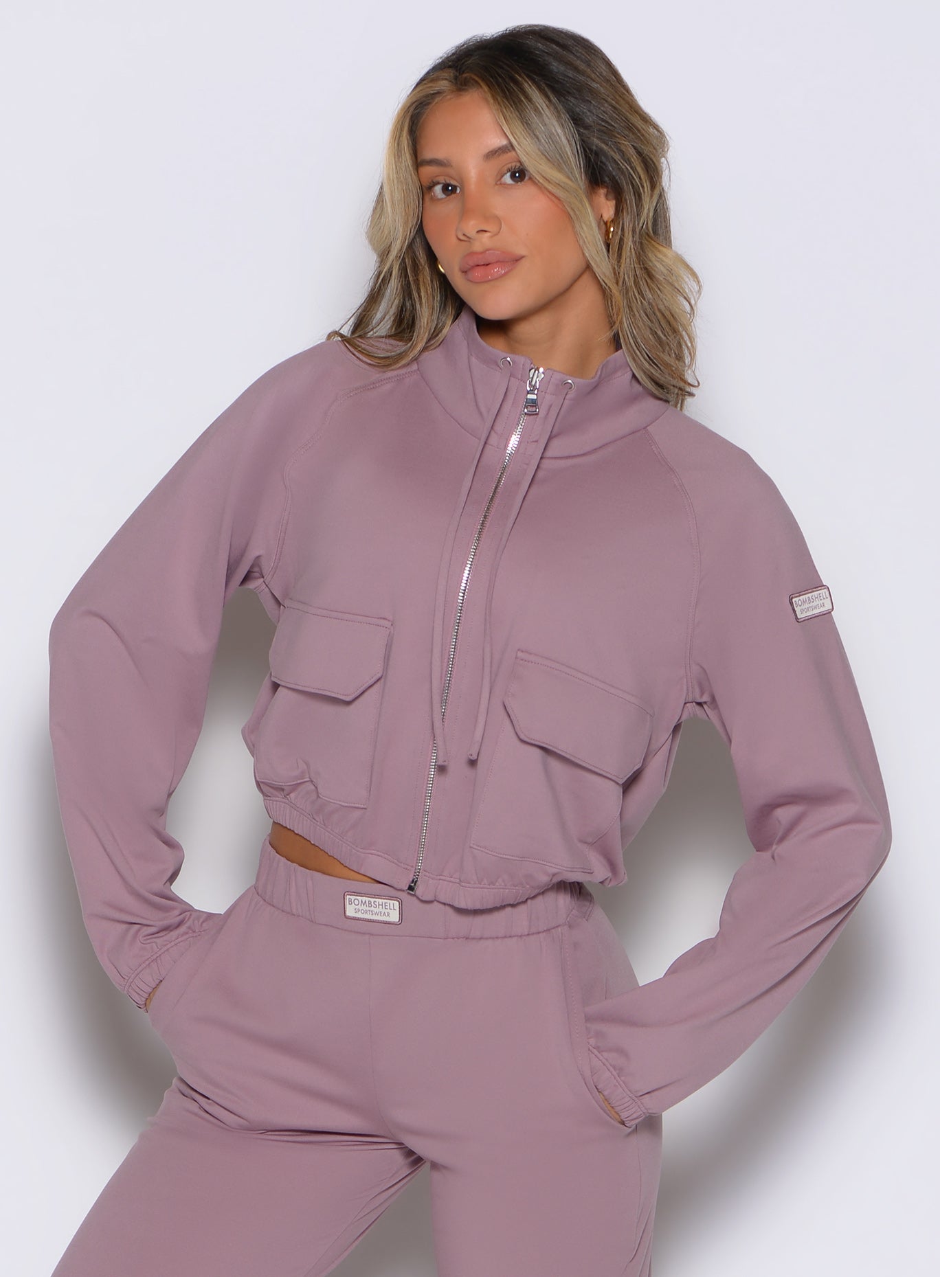 front view of a model wearing the Society Bomber Jacket in light mauve color