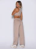 back left side view of a model looking over her shoulder wearing the Society Joggers in Camel color