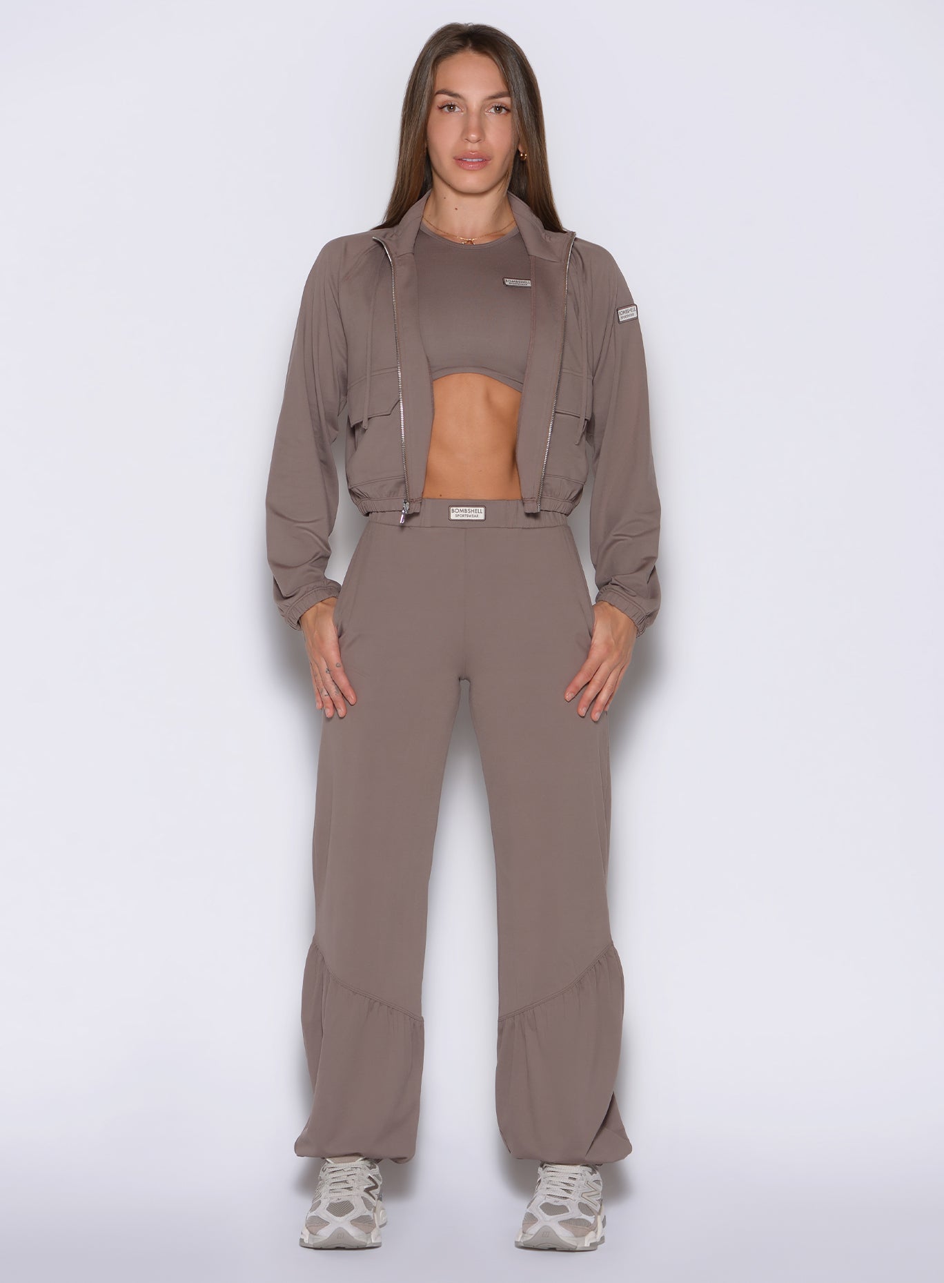 front profile view of a model wearing the Society Joggers in Espresso color paired with the matching tank and jacket