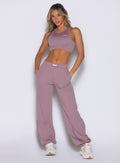front view of a model with both hands inside the side pockets wearing the Society Joggers in light mauve color