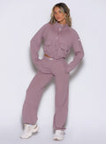 front view of a model with both hands inside the side pockets wearing the Society Joggers in light mauve color paired with the matching jacket 