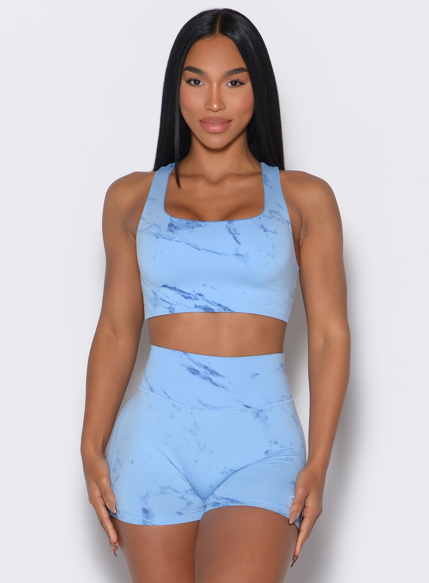 Front profile view of our model facing forward wearing the Square Neck Bra in Blue Jay color and the matching shorts