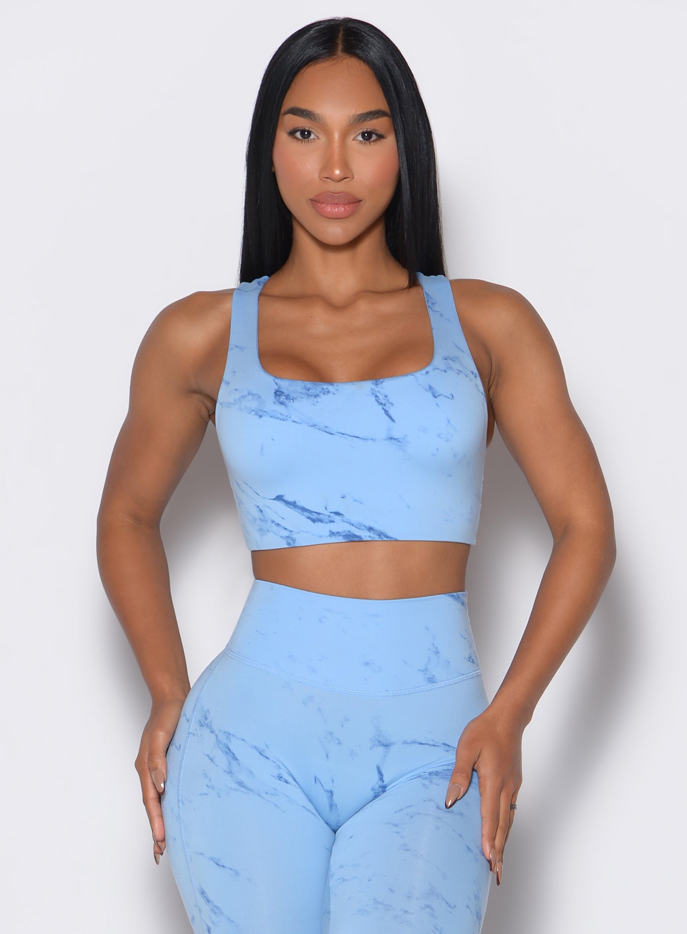 Front profile view of our model wearing the Square Neck Bra in Blue Jay color along with a matching leggings 