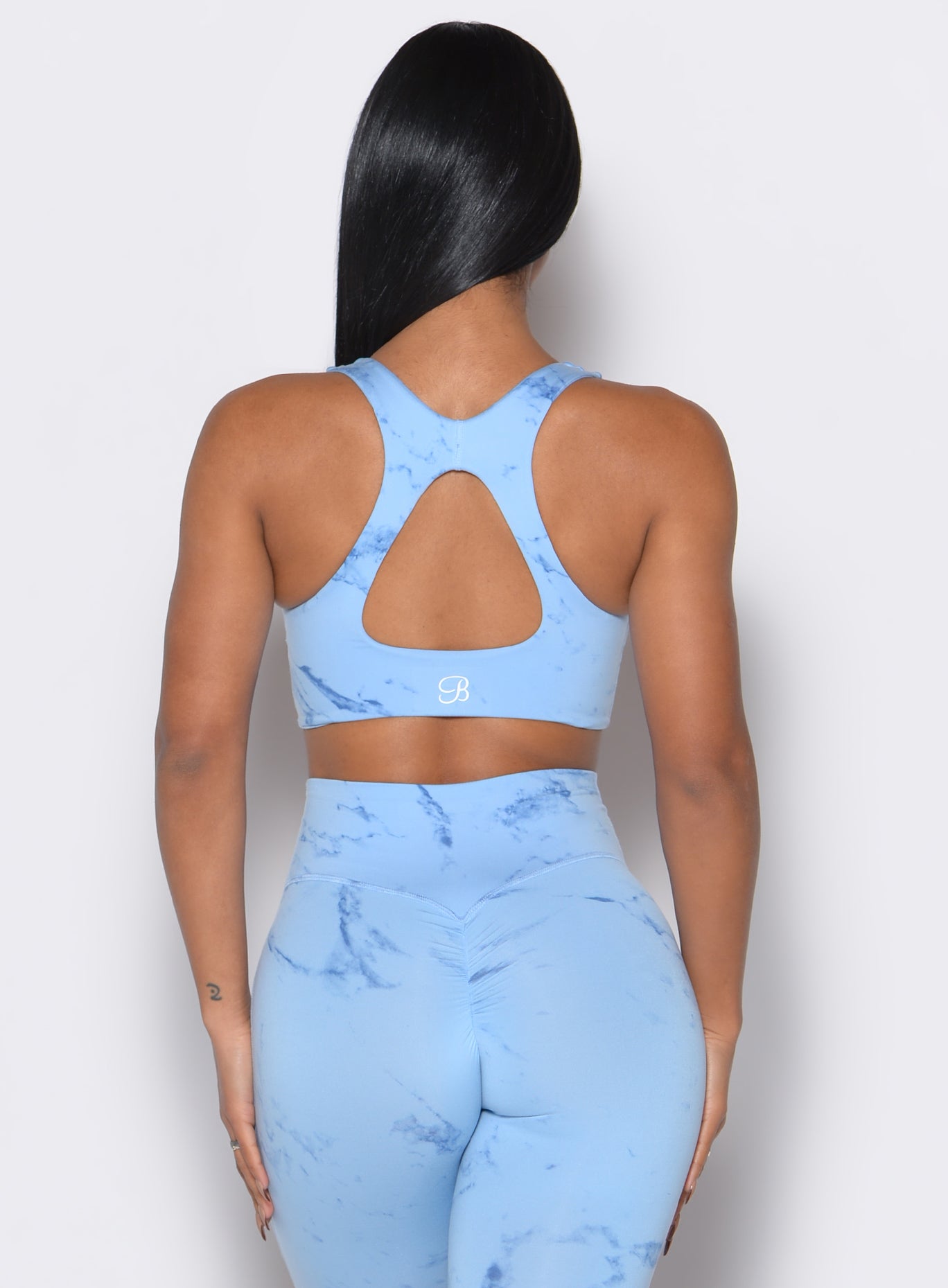 Back profile view of our model wearing the Square Neck Bra in Blue Jay color along with a matching leggings