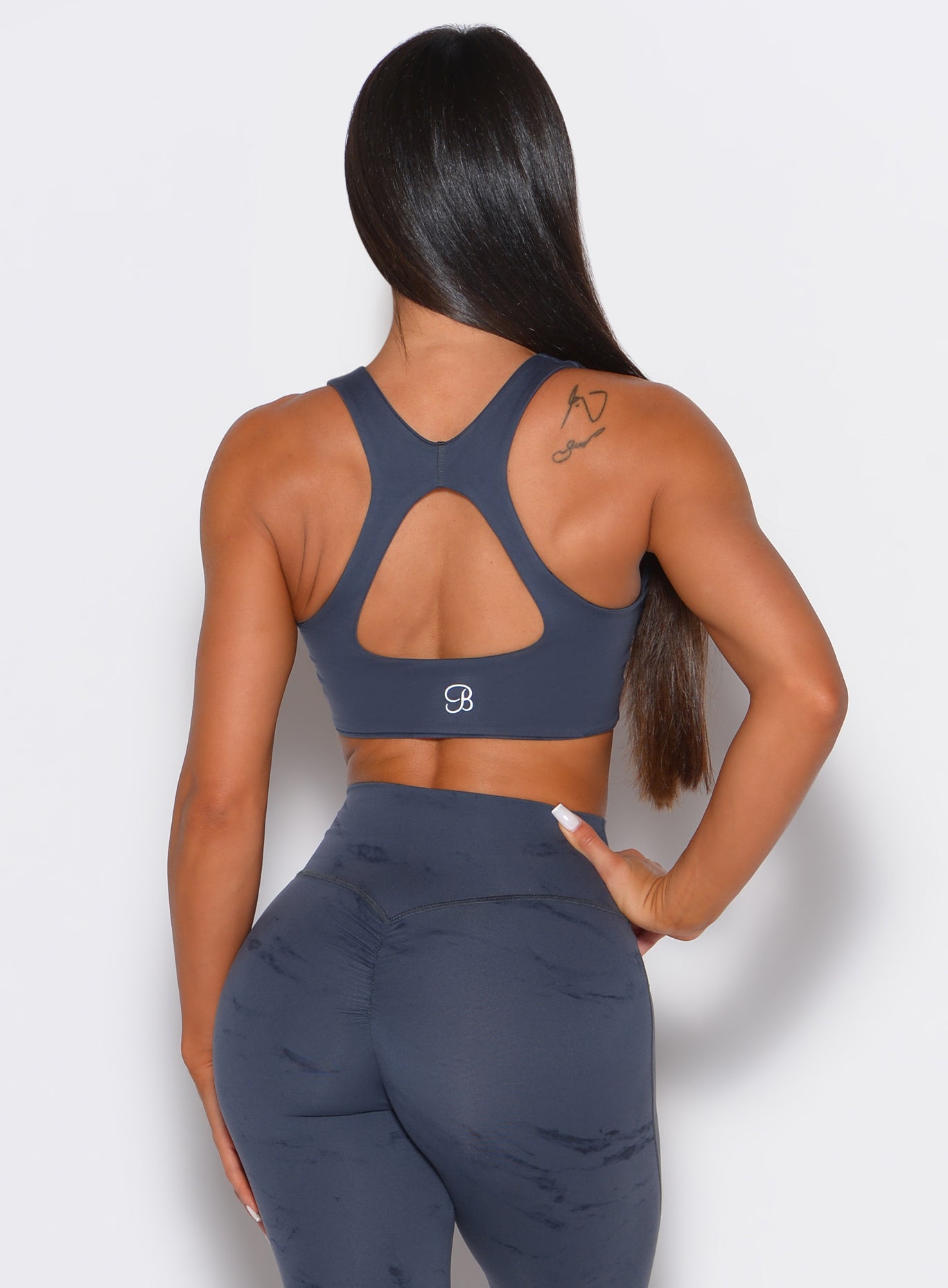 Back profile view of our model wearing the Square Neck Bra in Thunder Gray color along with a matching leggings 