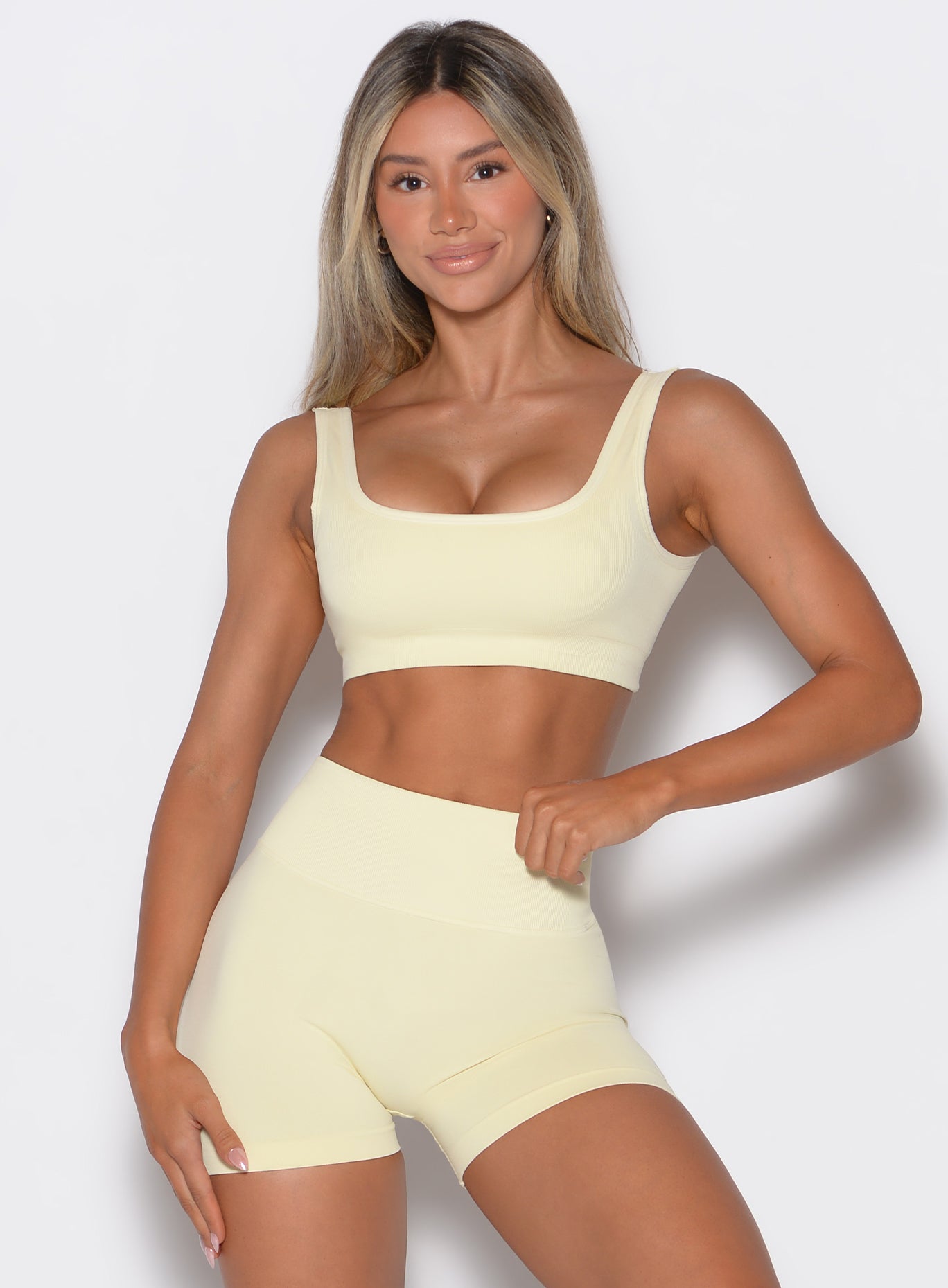 front profile view of a model wearing our square neck bra in Mellow Yellow color along with a matching pair of shorts