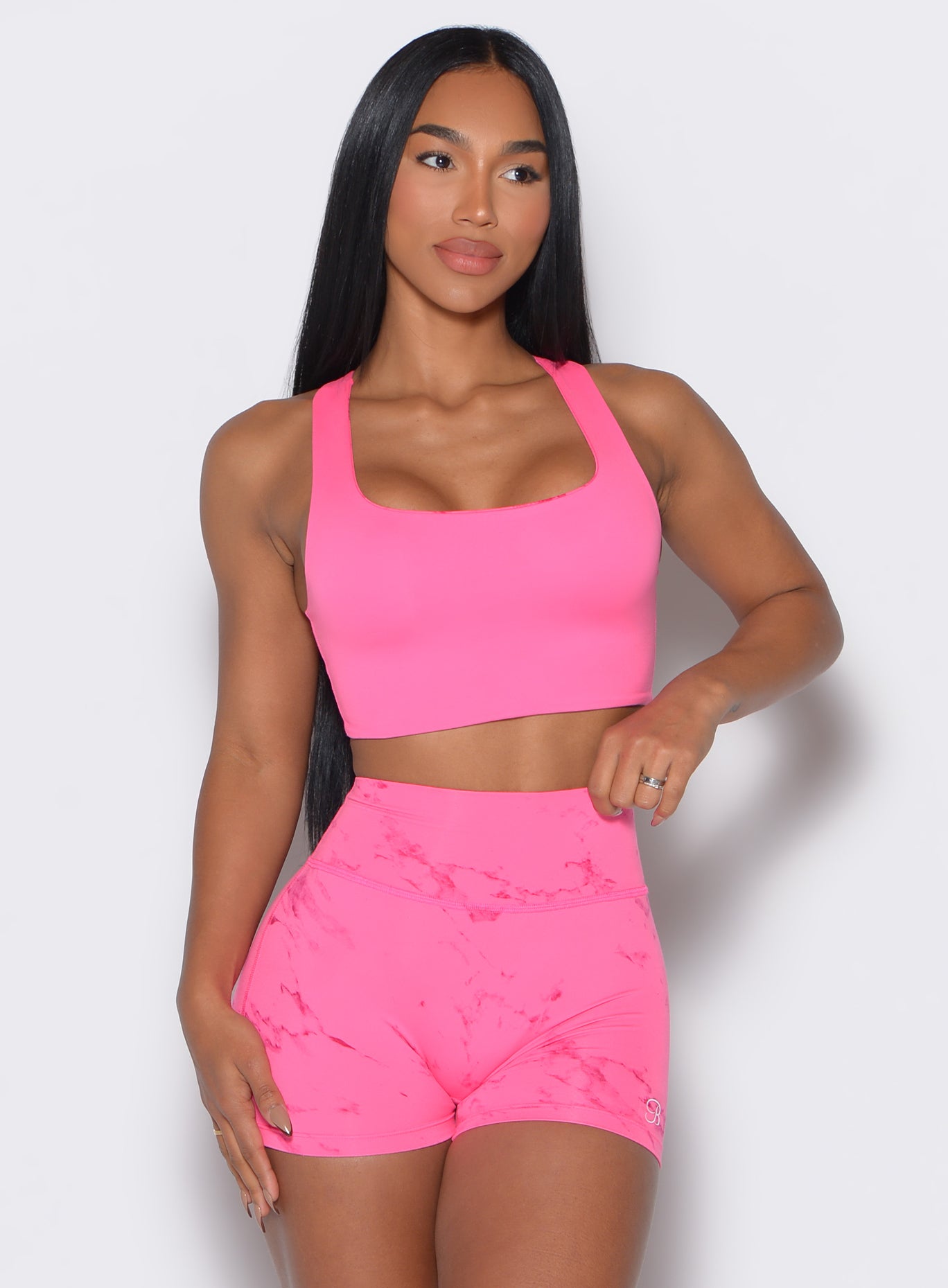 Front profile view of our model holding the waistband of the shorts wearing the  Square Neck Bra in cotton candy skies color along with the matching shorts