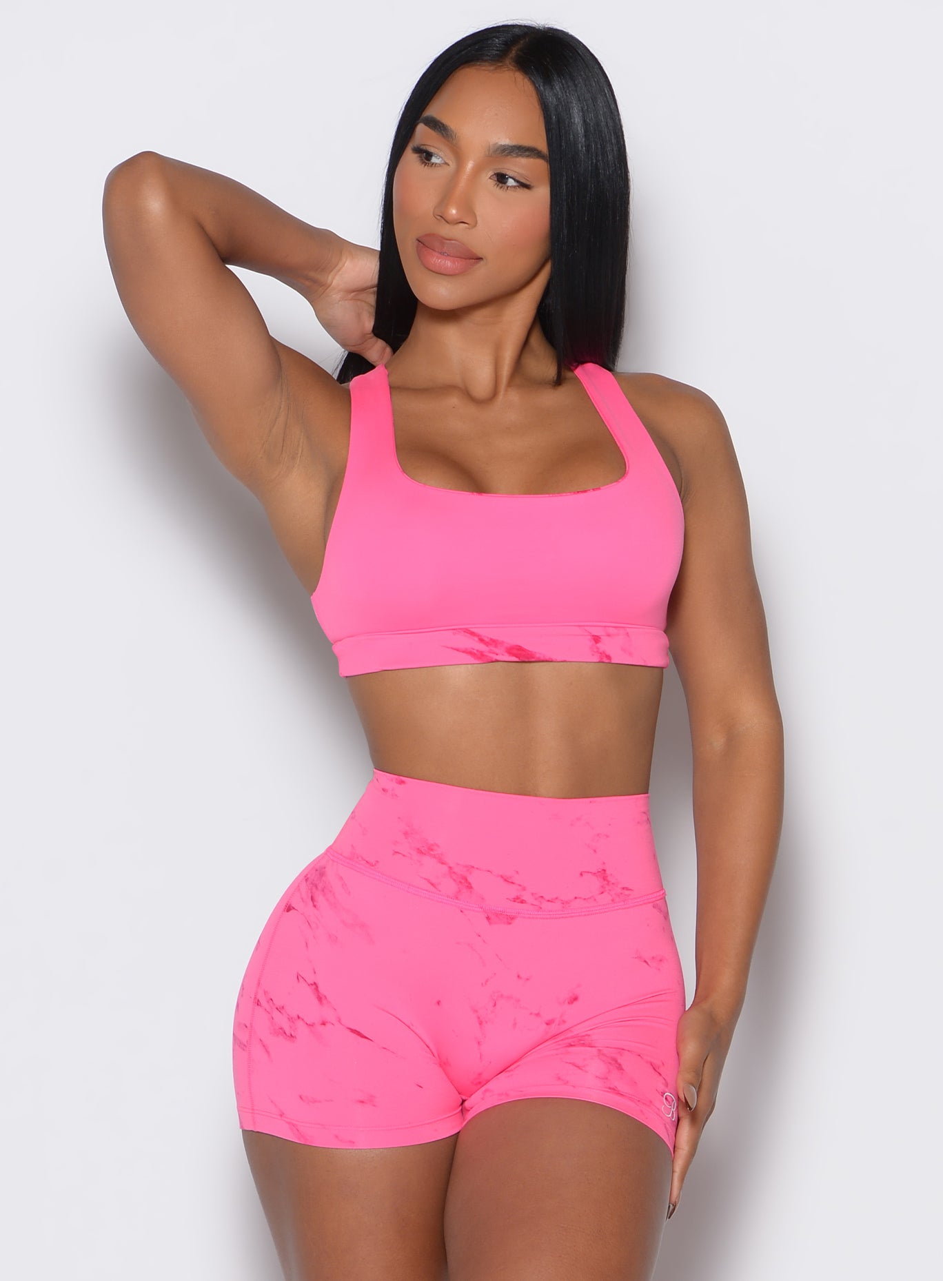 Front profile view of our model holding her hair and facing to the left wearing our  Square Neck Bra in cotton candy skies color along with a matching shorts 