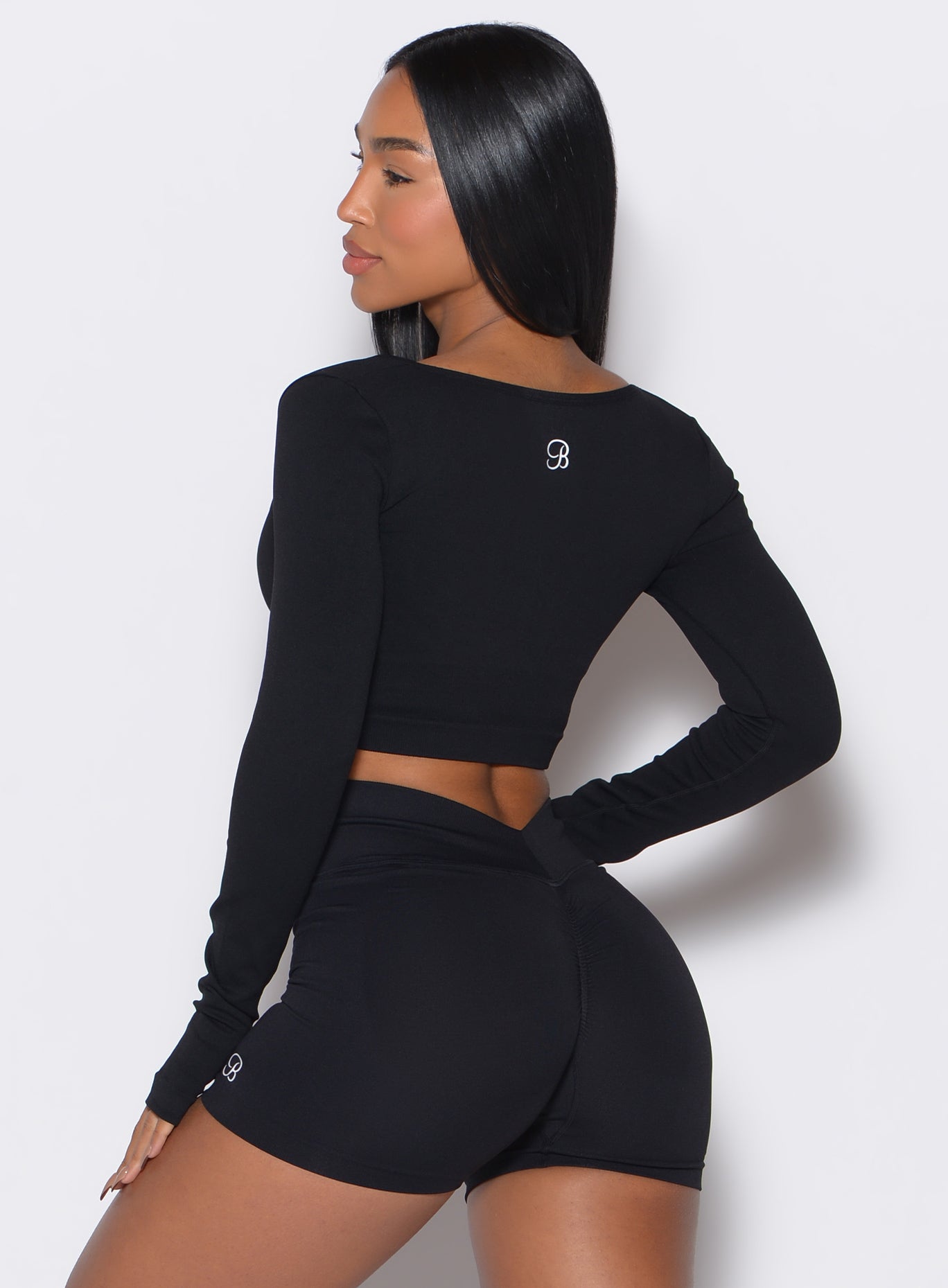back profile view of a model wearing our black square neck seamless pullover complemented by a matching shorts