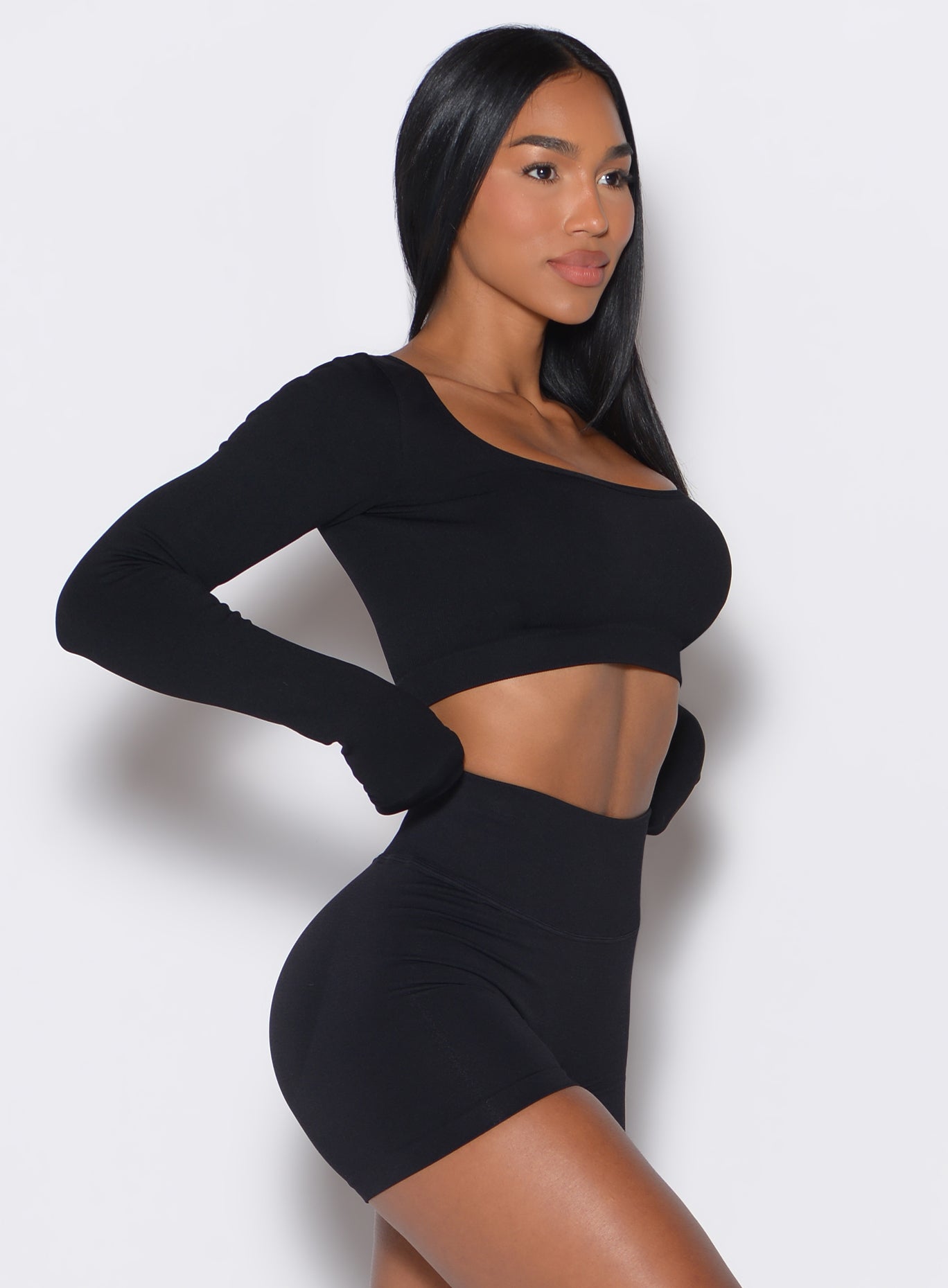 right side profile view of a model wearing our black square neck seamless pullover complemented by a matching shorts