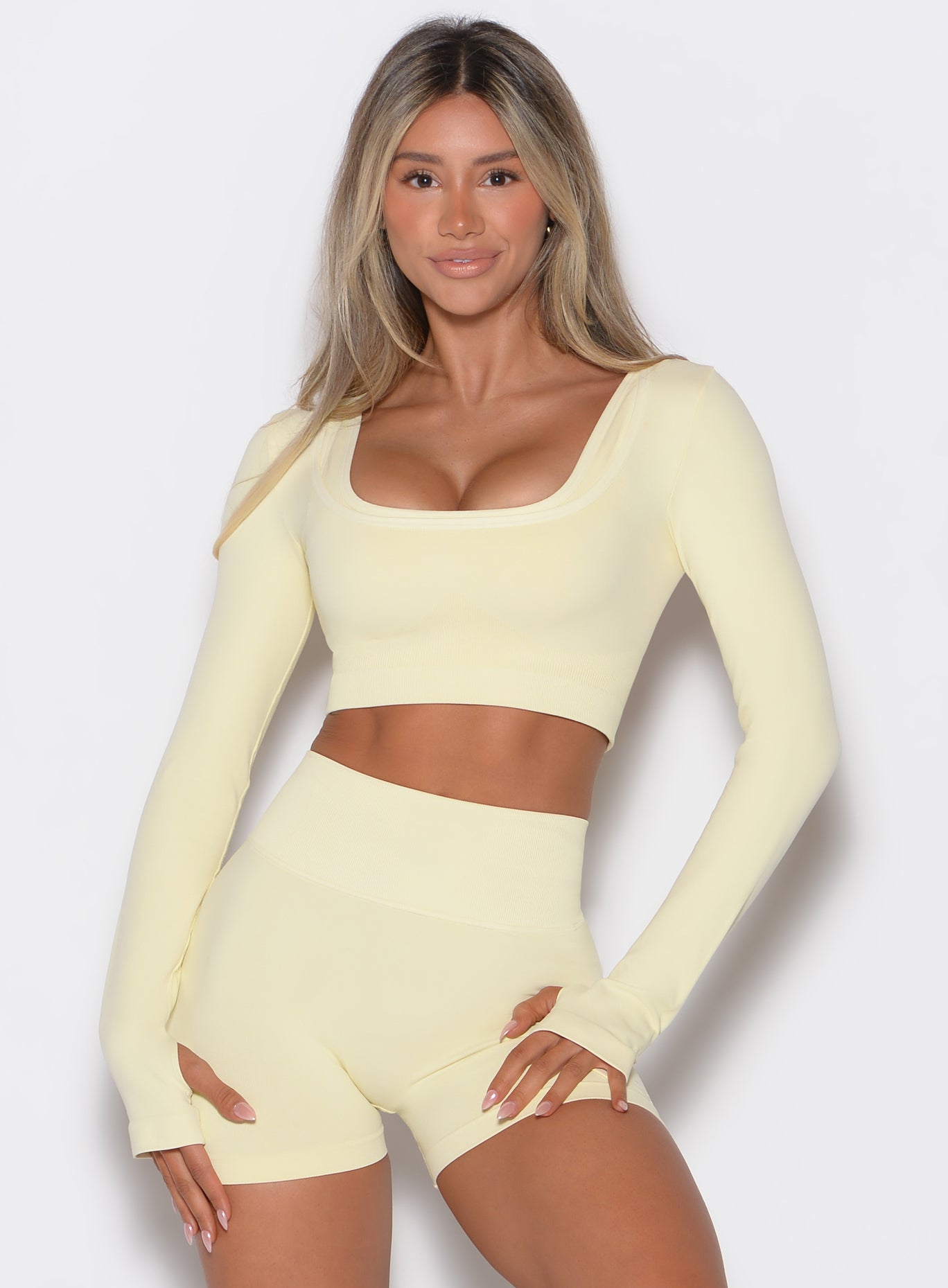 front profile view of a model wearing our square neck pullover in Mellow Yellow color complemented with the matching pair of shorts
