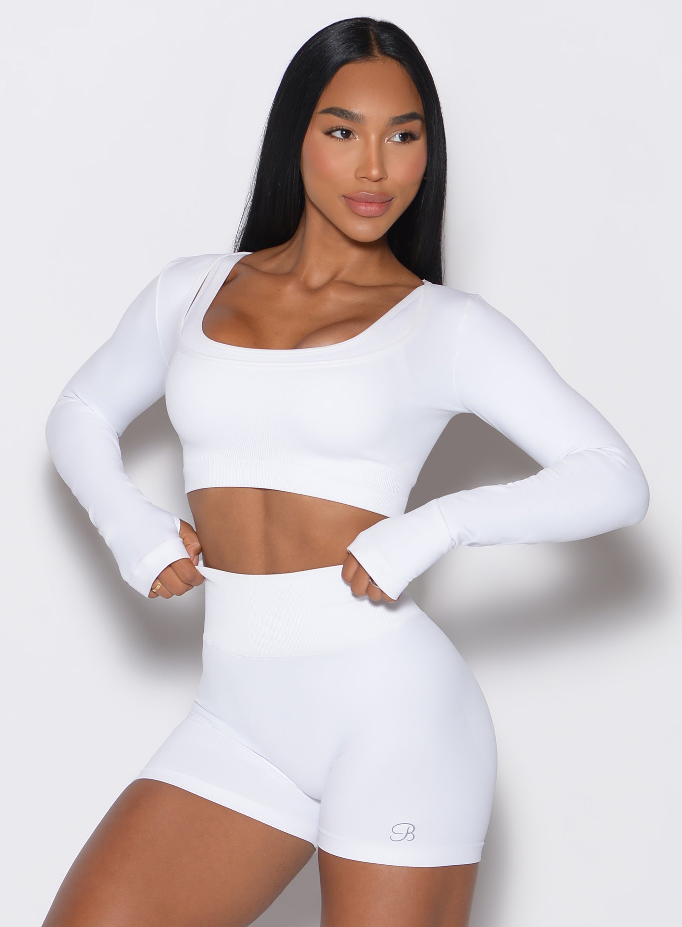 front profile view of a model facing to her left wearing our white square neck seamless pullover complemented by a matching shorts