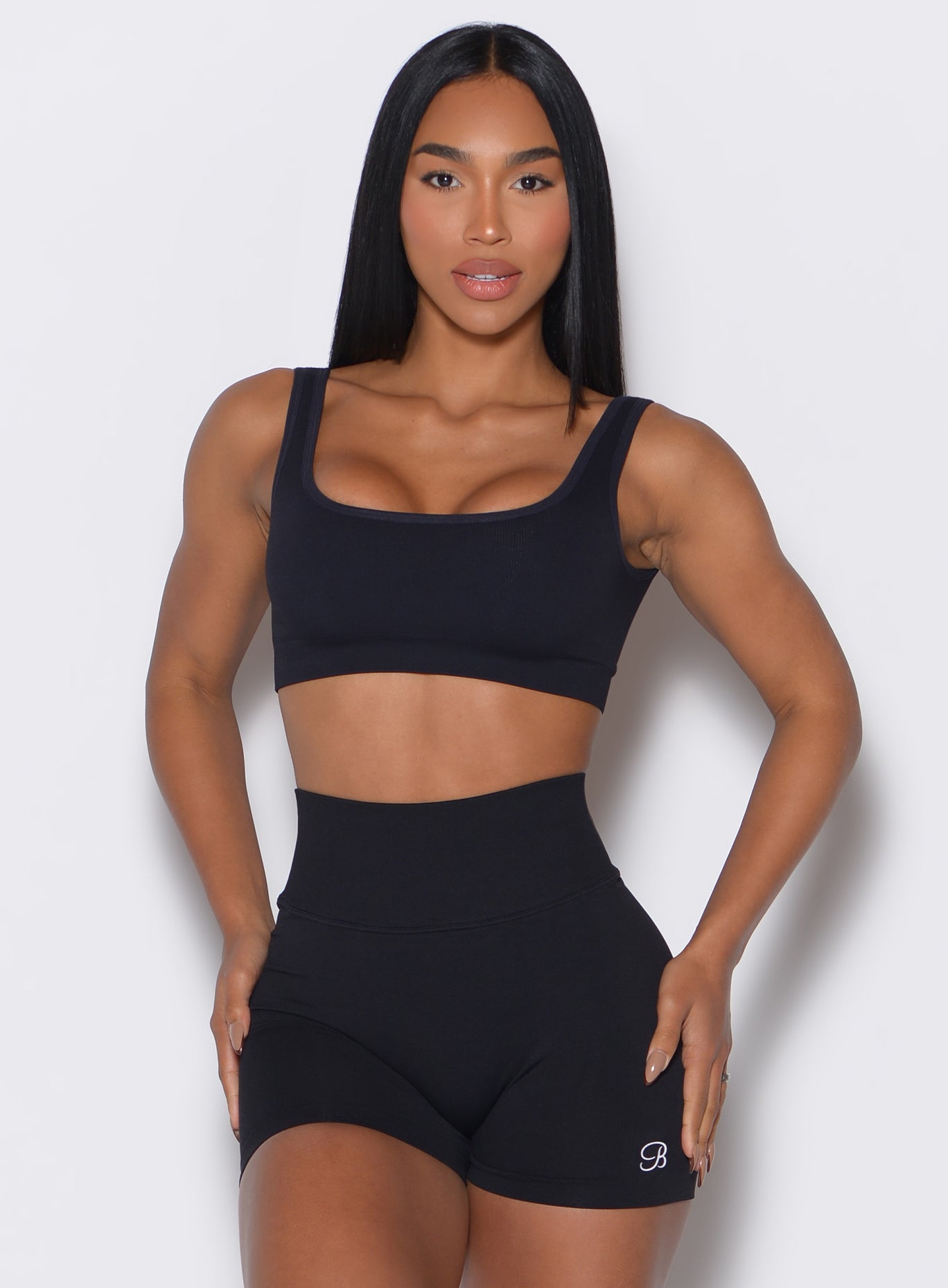 front profile view of a model wearing our black square neck bra along with the matching shorts 
