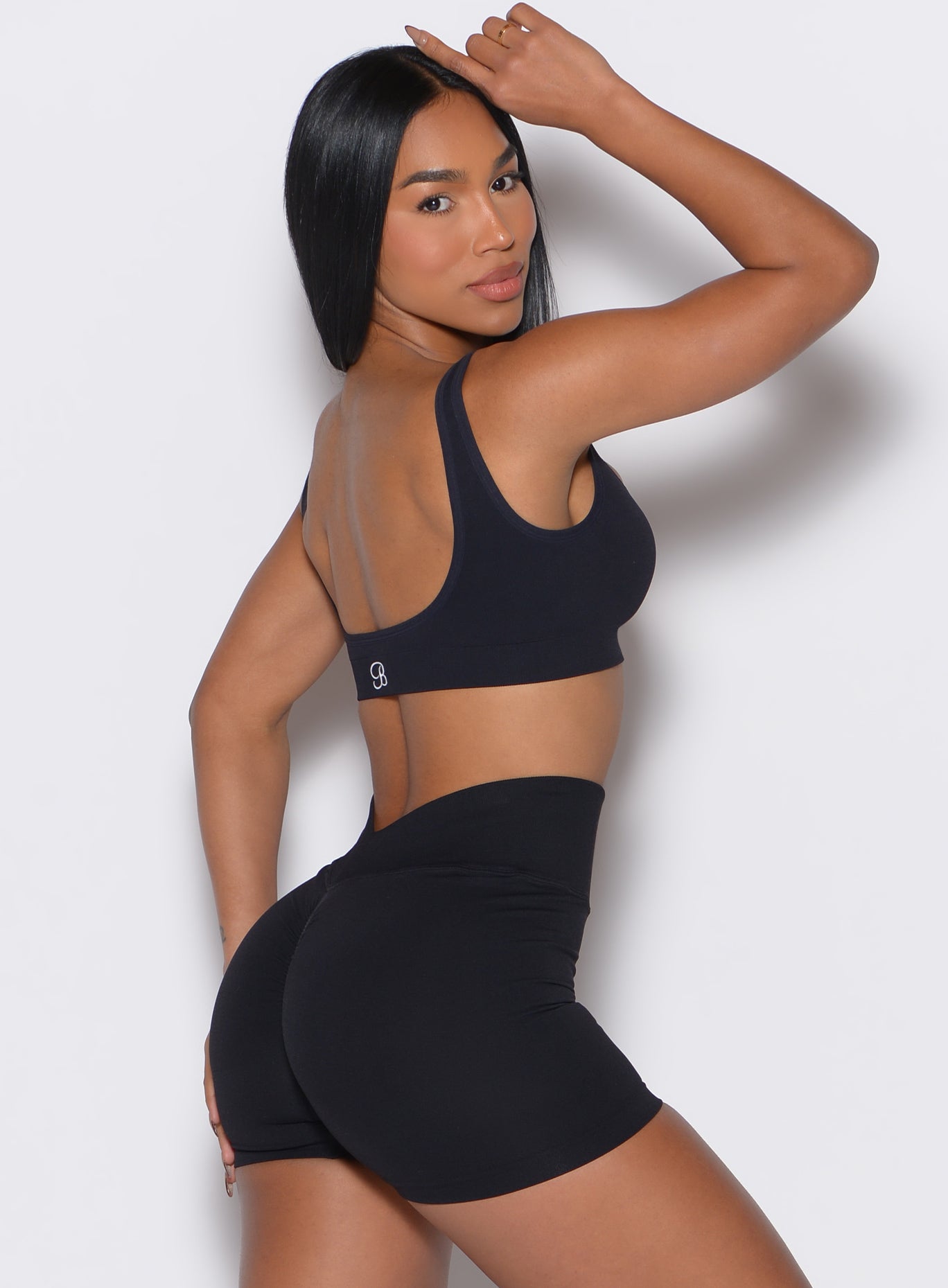 Right side profile view of a model wearing our black square neck bra along with the matching shorts