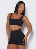 front  profile view of a model wearing our black square neck bra complemented by the matching shorts