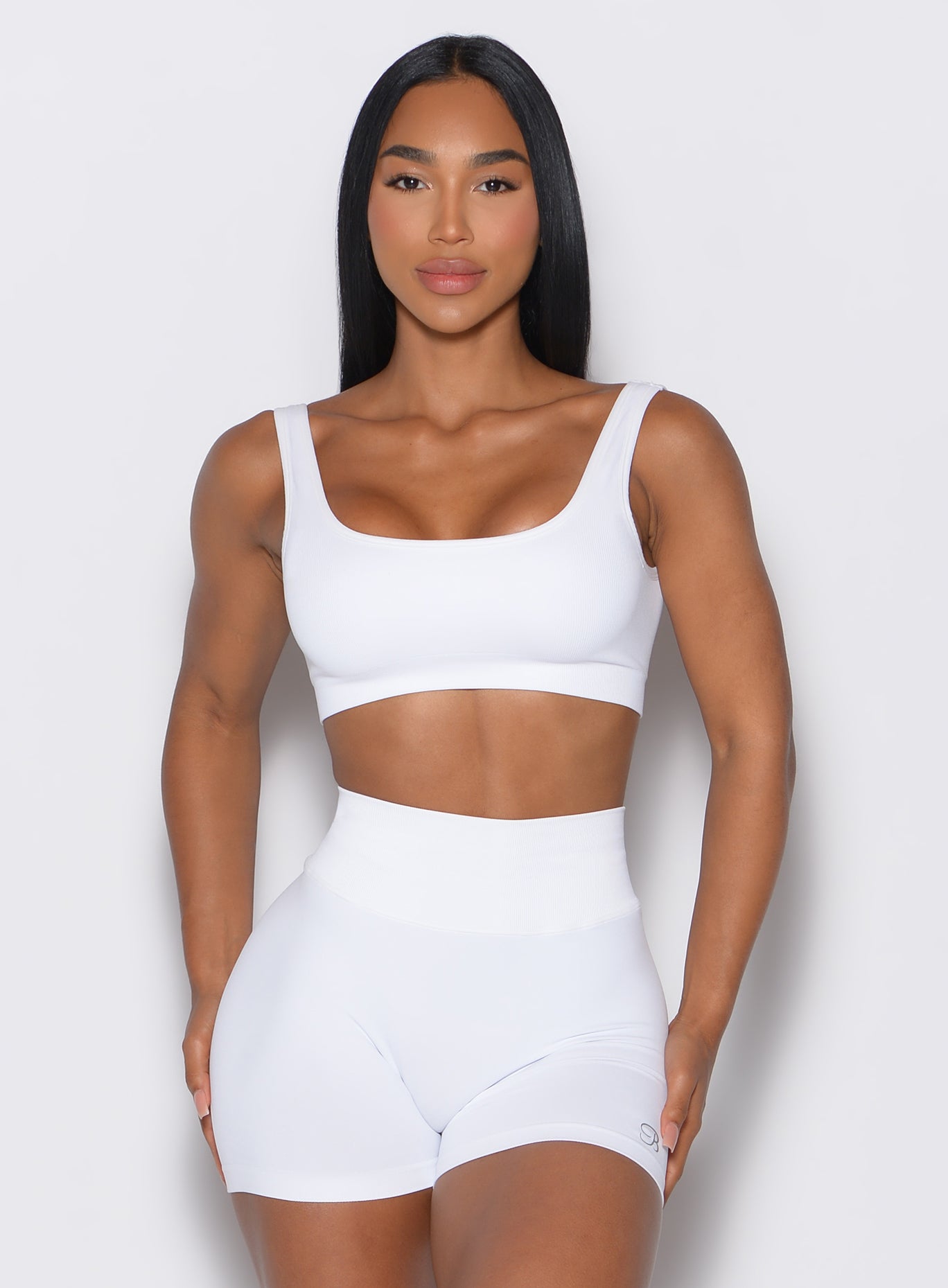 front profile view of a model facing forward wearing our white square neck bra  along with a matching shorts 