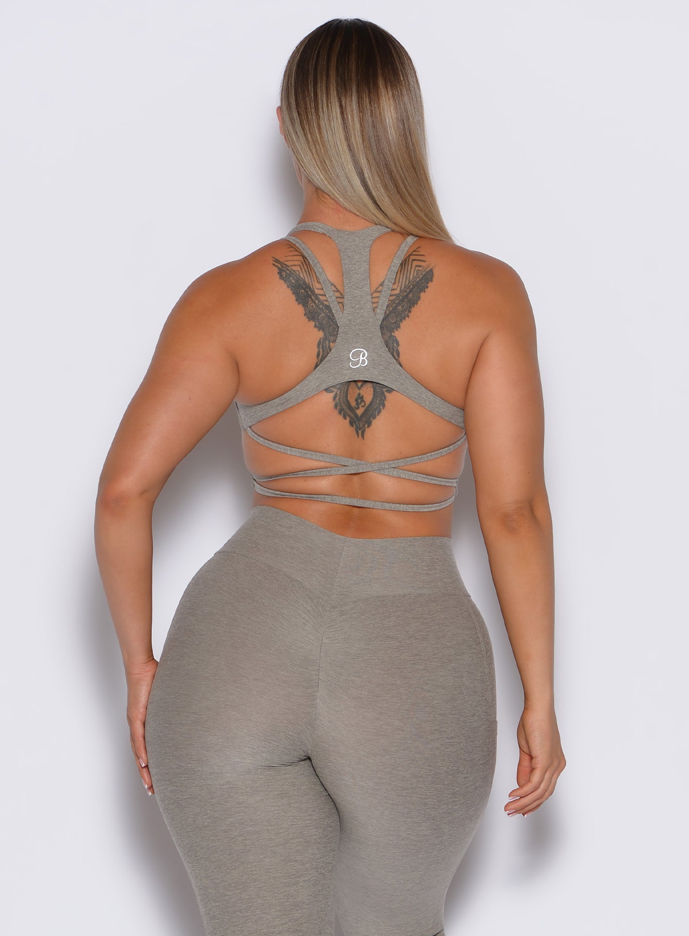 back profile picture of a model wearing our viral tank bra in nori color along with the matching curves  leggings