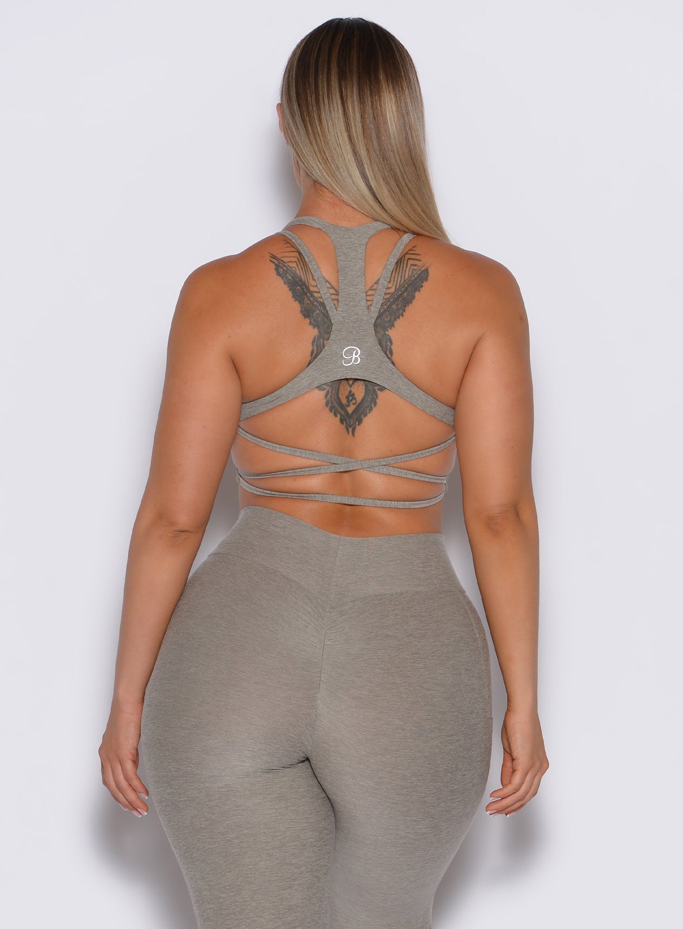 back profile picture of a model wearing our viral tank bra in nori color along with the matching leggings