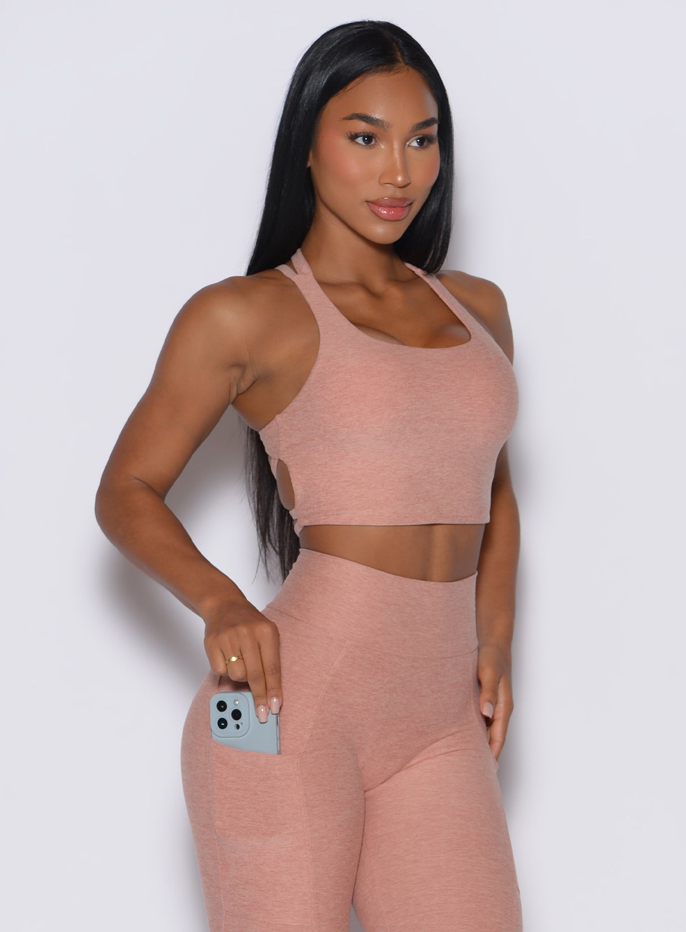 front  profile picture of a model wearing our viral tank bra in nude sand color along with the matching leggings