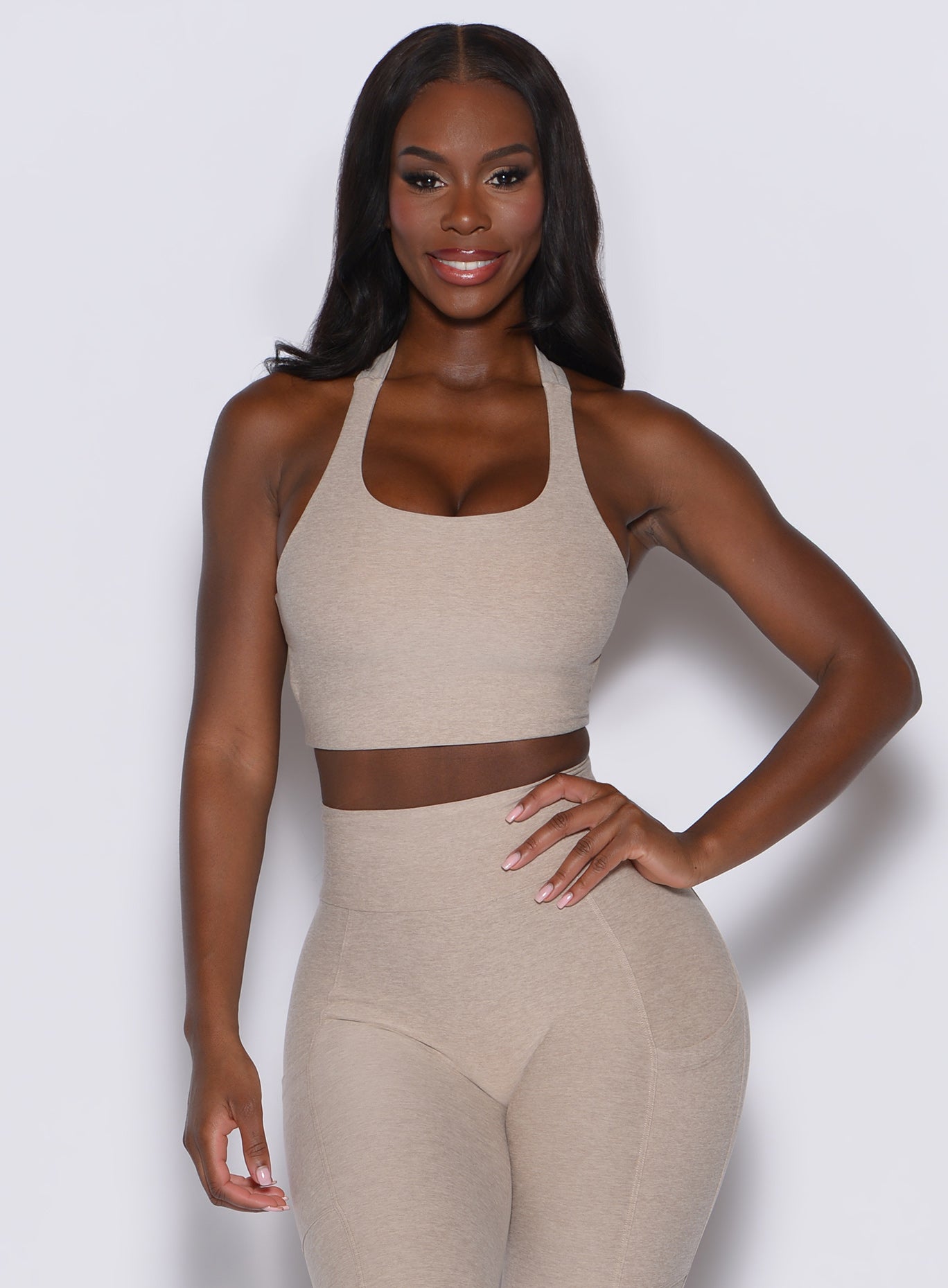 front profile picture of a model facing forward wearing our viral tank bra in taupe color along with the matching leggings