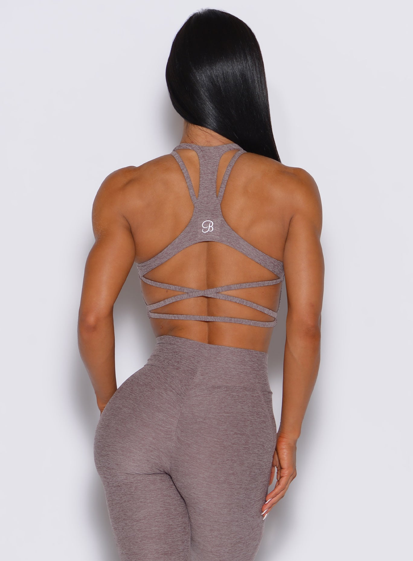 back profile view of a model wearing our viral tank bra in london fog color along with the matching leggings