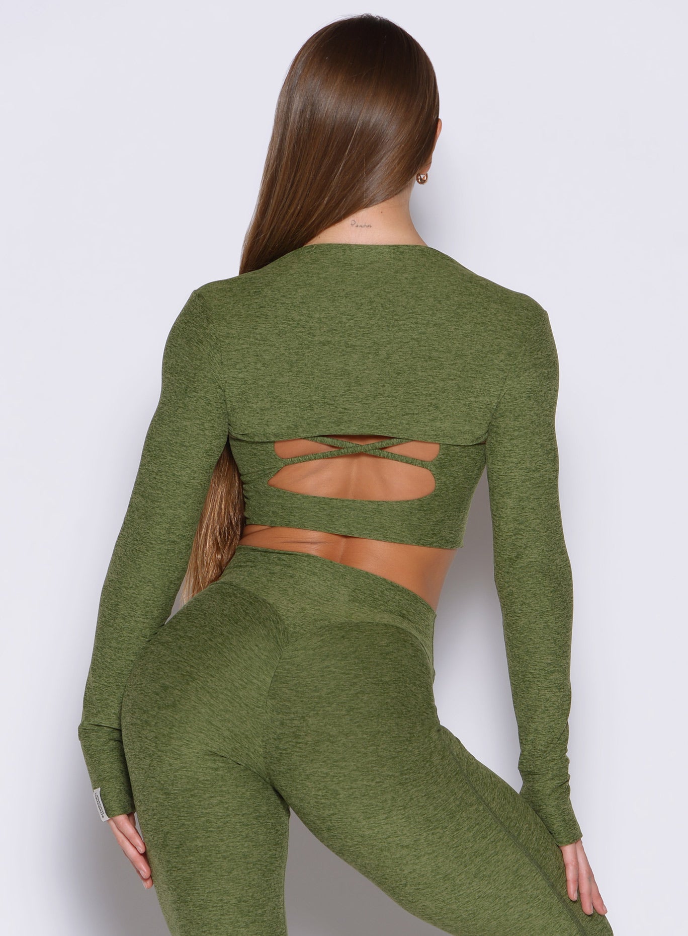 Juniper Studio Sculpt Bolero in a soft heathered knit, featuring a sleek back and thumbhole cuffs.