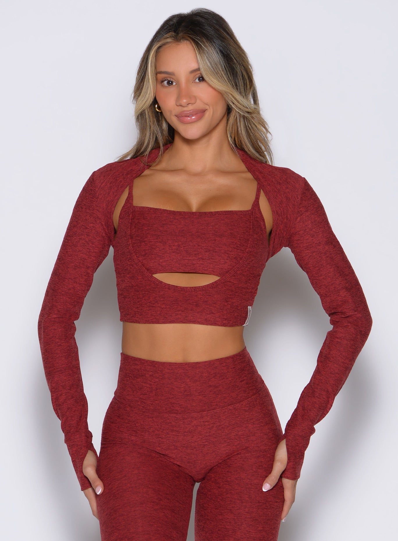 front view of a model with both hands resting on her thighs wearing the Studio Sculpt Bolero in Rouge color